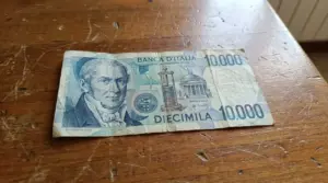 Banconota italiana da 10.000 lire con Alessandro Volta appoggiata su un tavolo di legno