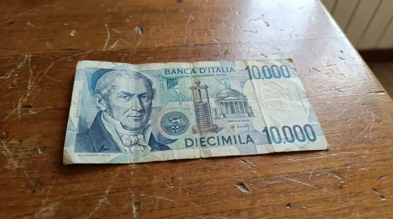 Banconota italiana da 10.000 lire con Alessandro Volta appoggiata su un tavolo di legno