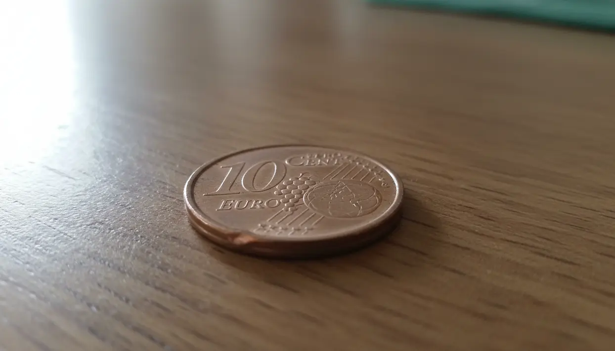 Moneta da 10 centesimi di euro del 2002 su una superficie in legno