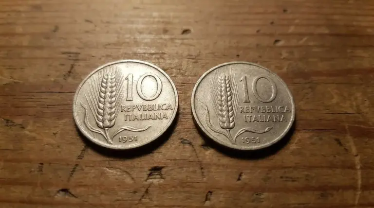 Due monete da 10 lire del 1951 affiancate su un tavolo di legno, con spiga di grano e scritta Repubblica Italiana