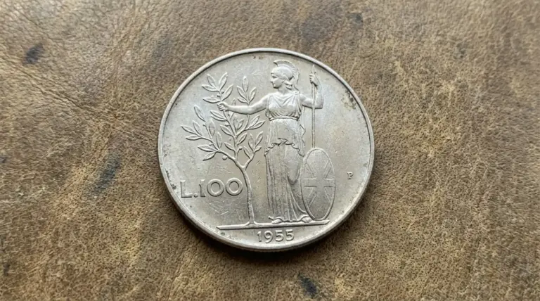 Moneta da 100 lire Minerva 1955 su superficie in pelle, con figura femminile e ramo d’ulivo