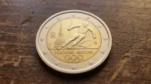 Moneta da 2 euro commemorativa Torino 2006 con sciatore e Mole Antonelliana su un tavolo di legno