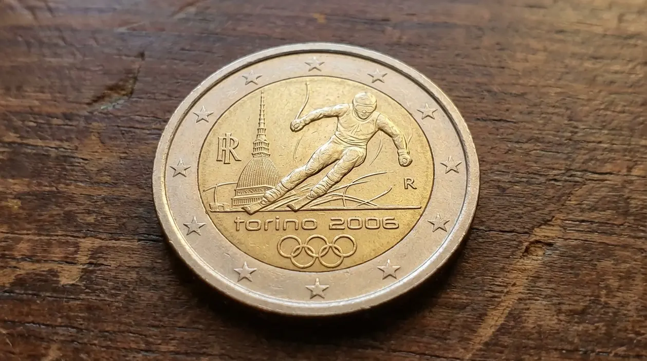 Moneta da 2 euro commemorativa Torino 2006 con sciatore e Mole Antonelliana su un tavolo di legno