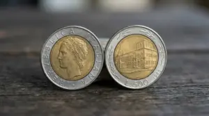 Due monete da 500 lire bimetalliche del 1982 fotografate fronte e retro su un piano in legno