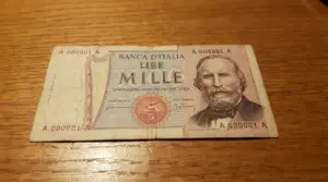 Banconota da 1.000 lire con Garibaldi appoggiata su un tavolo, con numero di serie basso ben visibile
