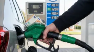 Rifornimento di carburante a un’auto con banconote inserite nella pistola della pompa benzina
