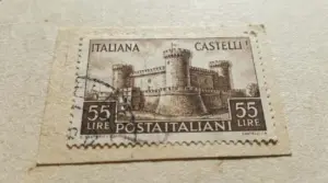 Francobollo italiano Castelli da 55 lire con annullo, in primo piano su carta, dettaglio del disegno del castello.
