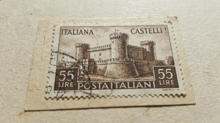 Francobollo italiano Castelli da 55 lire con annullo, in primo piano su carta, dettaglio del disegno del castello.