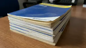 Pila di libretti postali su una scrivania, simbolo di risparmi e controlli su libretti dormienti