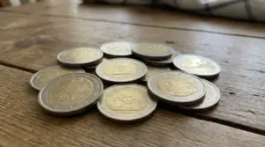 Mucchio di monete commemorative da 2 euro su un tavolo di legno, fotografate in primo piano