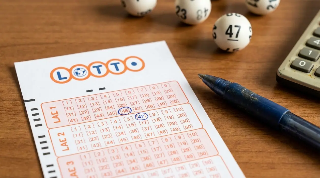 Schedina del lotto su un tavolo con numeri cerchiati, penna e palline numerate accanto