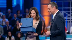 Donna apre un pacco in studio televisivo accanto al conduttore durante una puntata di Affari Tuoi