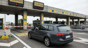 Auto al casello Telepass con sbarra abbassata e luce rossa, telepedaggio bloccato in autostrada